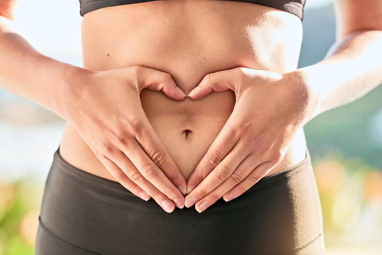 woman making a heart sign on her midsection